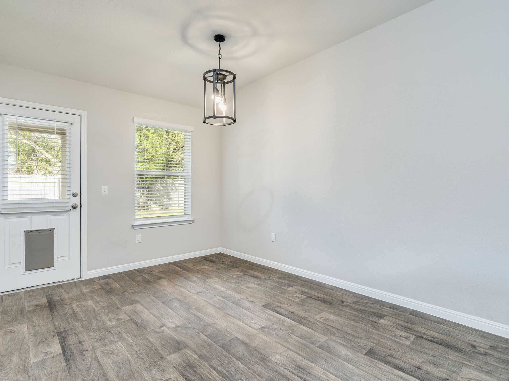 136 Dunlin Lane Leander, TX 78641 - Photo 19 of 24 Unfurnished dining area featuring baseboards and dark wood finished floors