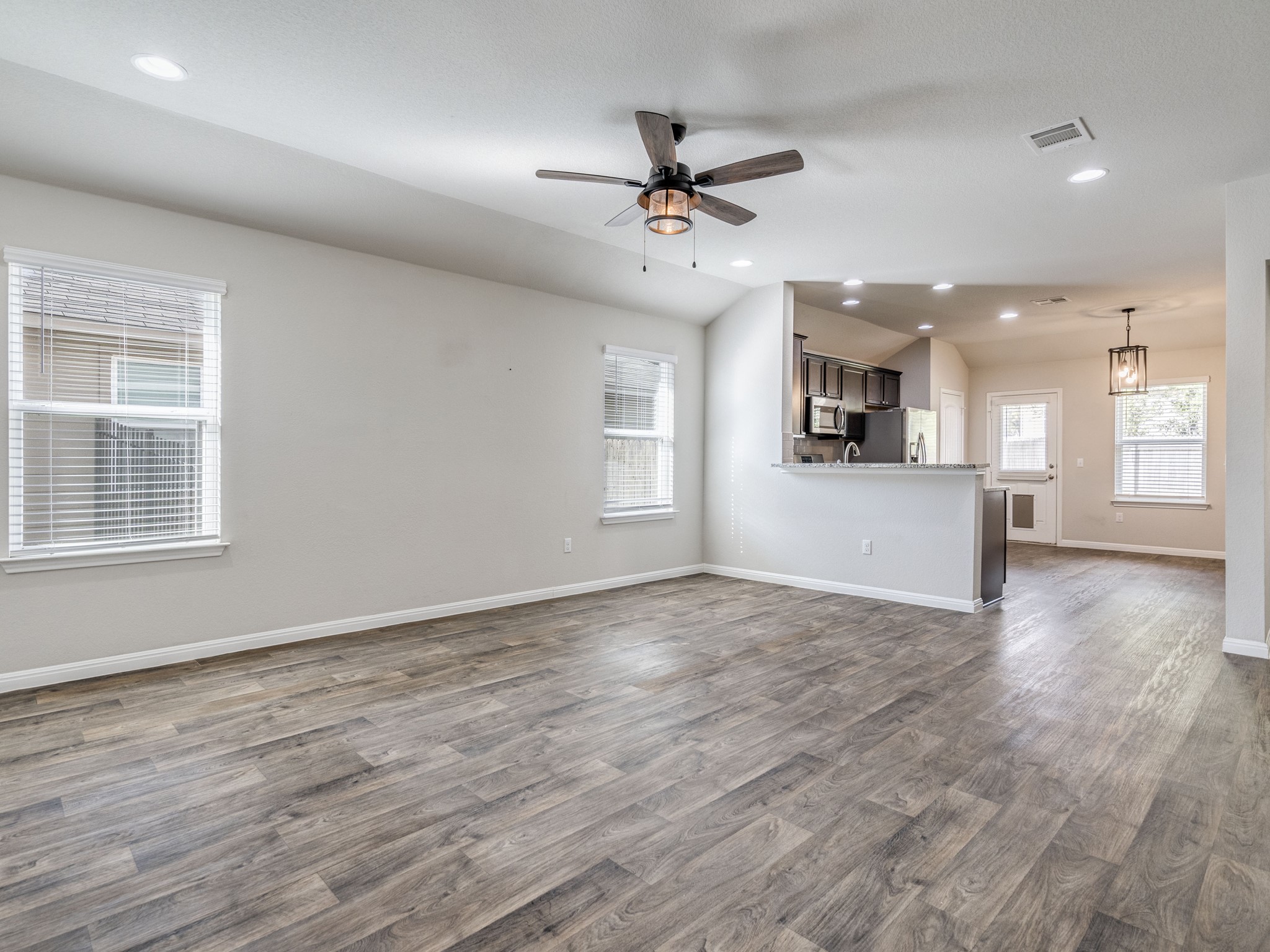 136 Dunlin Lane Leander, TX 78641 - Photo 5 of 24 Unfurnished living room featuring recessed lighting, ceiling fan, lofted ceiling, and dark wood-style floors