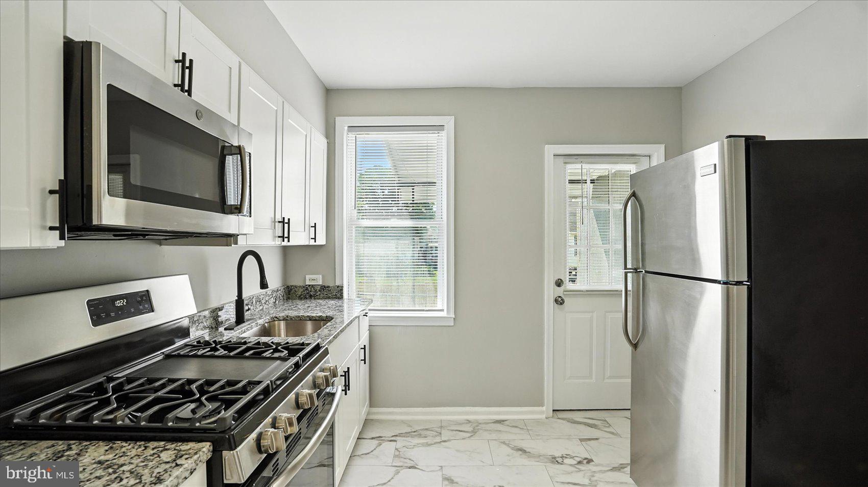 111 Eastern Boulevard Essex, MD 21221 - Photo 11 of 33 a kitchen with stainless steel appliances a refrigerator stove and sink