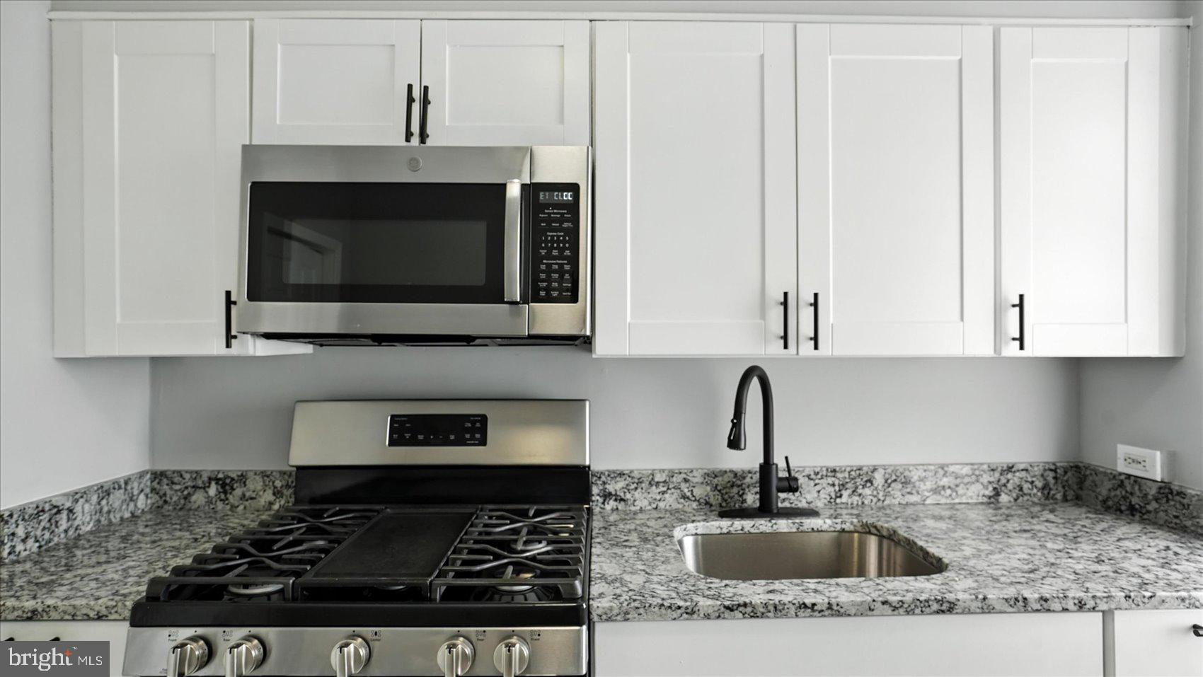 111 Eastern Boulevard Essex, MD 21221 - Photo 14 of 33 a kitchen with stainless steel appliances granite countertop a sink stove and microwave