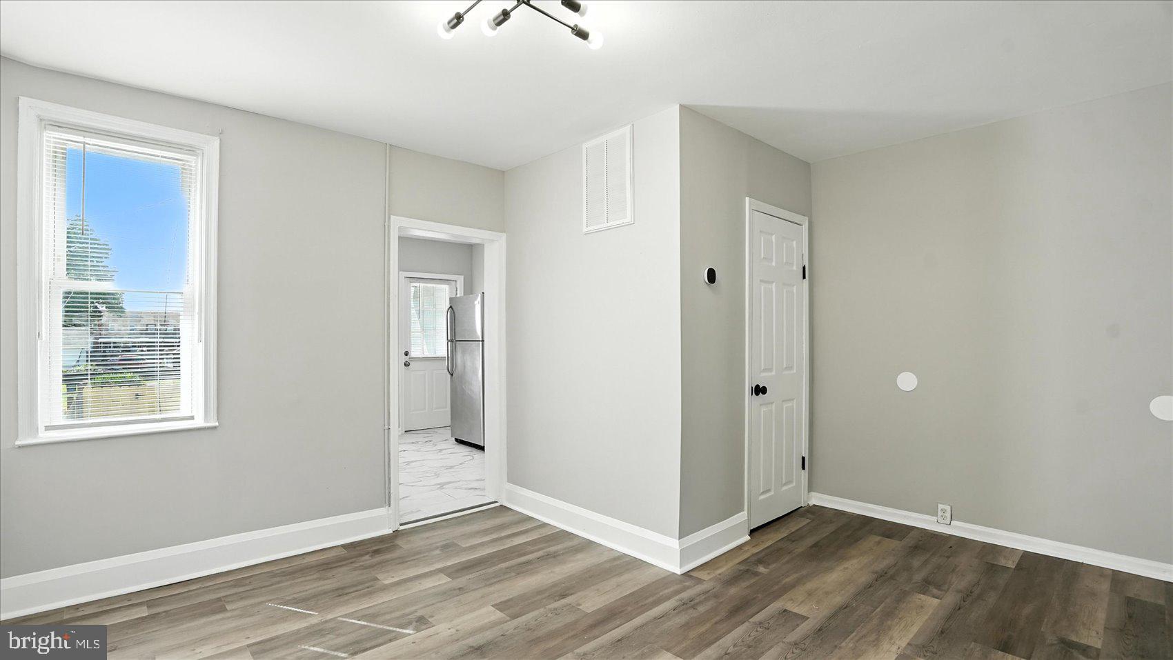 111 Eastern Boulevard Essex, MD 21221 - Photo 8 of 33 a view of an empty room with wooden floor and a window