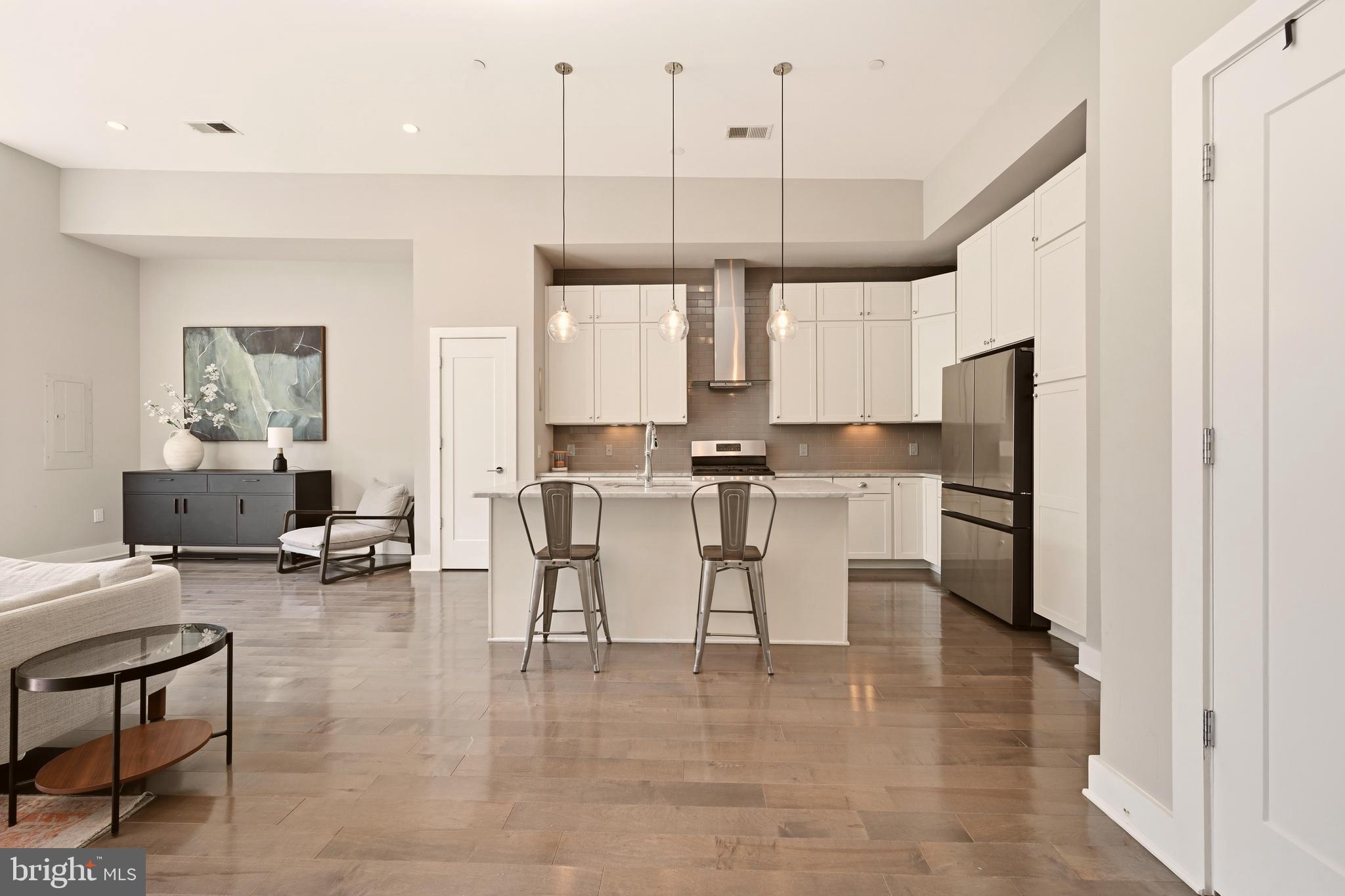 630 14th Street Northeast, Unit 5 Washington, DC 20002 - Photo 7 of 24 a kitchen with stainless steel appliances a table chairs refrigerator and cabinets