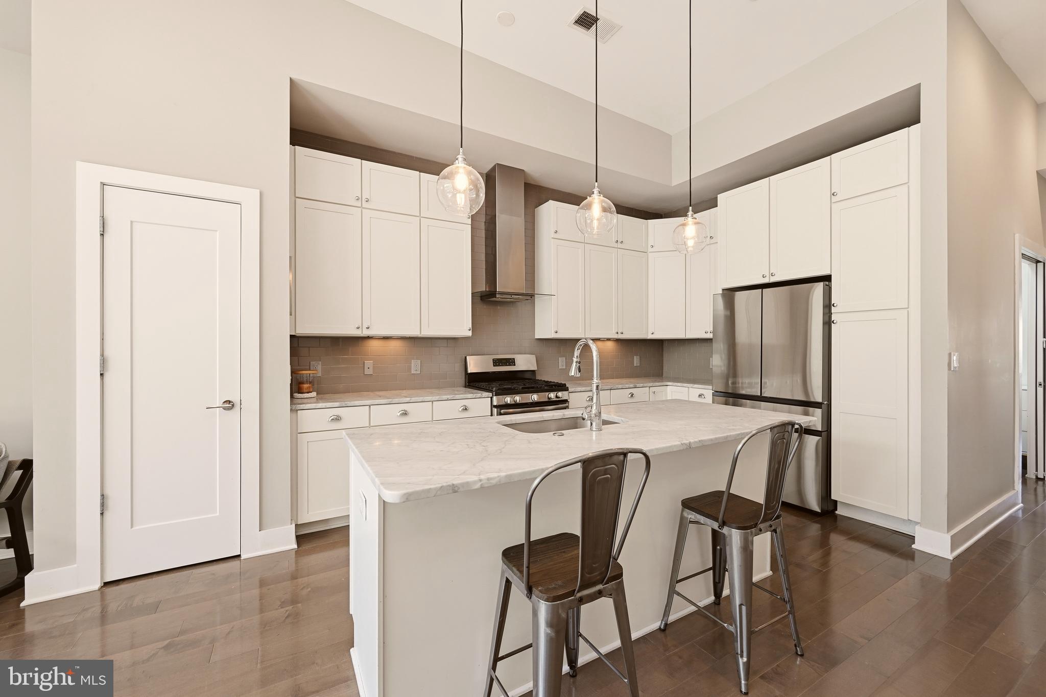630 14th Street Northeast, Unit 5 Washington, DC 20002 - Photo 8 of 24 a kitchen with stainless steel appliances a stove a sink island and a refrigerator