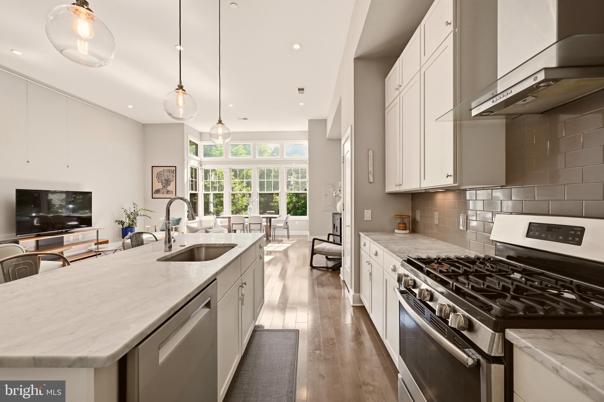 630 14th Street Northeast, Unit 5 Washington, DC 20002 - Photo 9 of 24 a kitchen with stainless steel appliances a sink a stove and a wooden floors