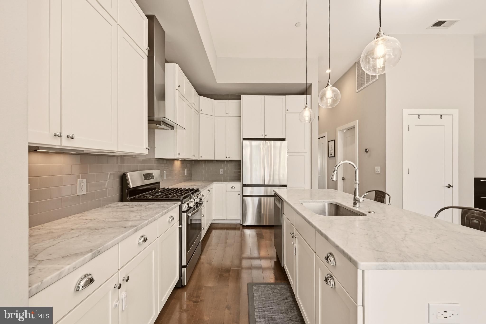 630 14th Street Northeast, Unit 5 Washington, DC 20002 - Photo 10 of 24 a kitchen with stainless steel appliances granite countertop a sink a stove and a wooden floors