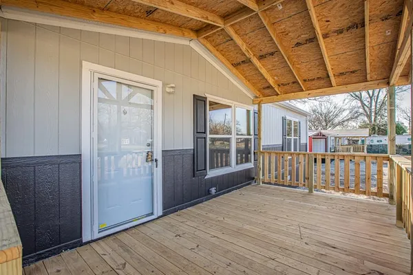 a view of a porch with wooden floor and fence