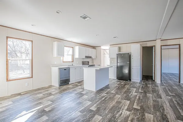 a kitchen with granite countertop a refrigerator and a stove top oven