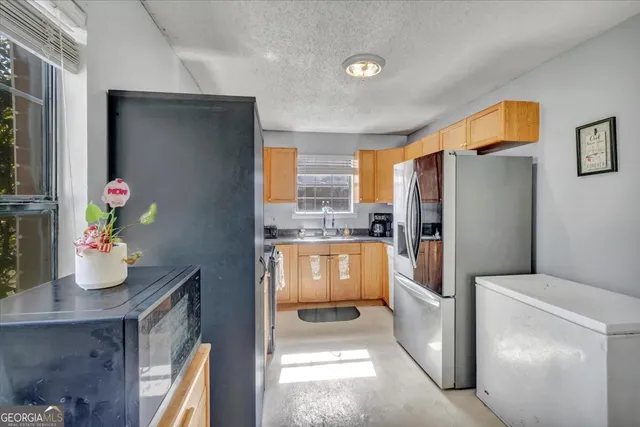 a kitchen with stainless steel appliances granite countertop a refrigerator and a sink