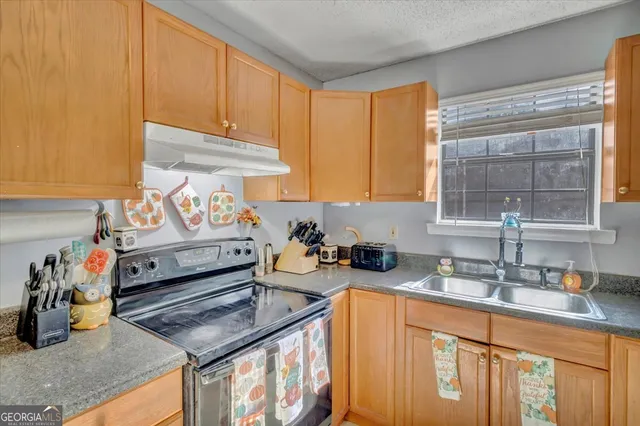 a kitchen with stainless steel appliances granite countertop a sink stove and cabinets