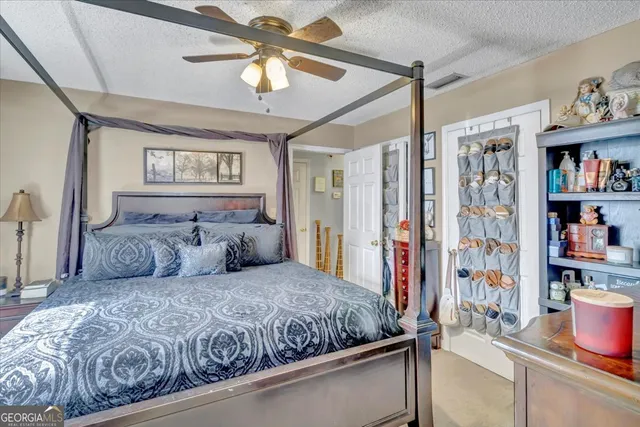 a bedroom with a large bed and a chandelier