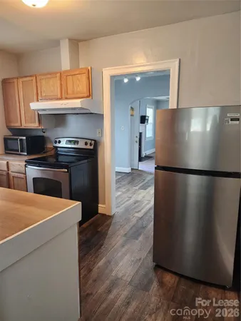 a kitchen with stainless steel appliances granite countertop a refrigerator a stove a sink and a microwave