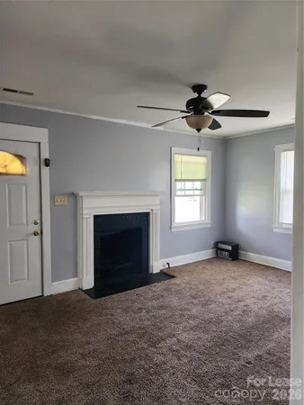 an empty room with windows and fireplace
