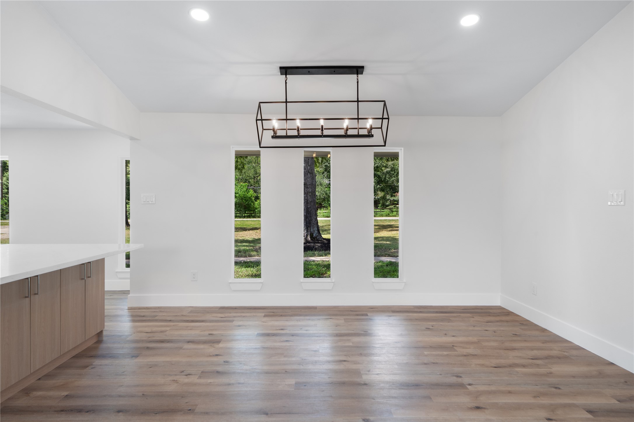 12019 Beth Lane Magnolia, TX 77354 - Photo 11 of 49 a view of an empty room with window wooden floor and kitchen view