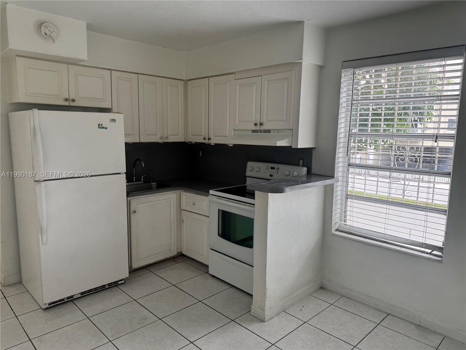 11 Southwest 32nd Avenue, Unit 4 Miami, FL 33135 - Photo 6 of 13 a kitchen with a white cabinets and white appliances