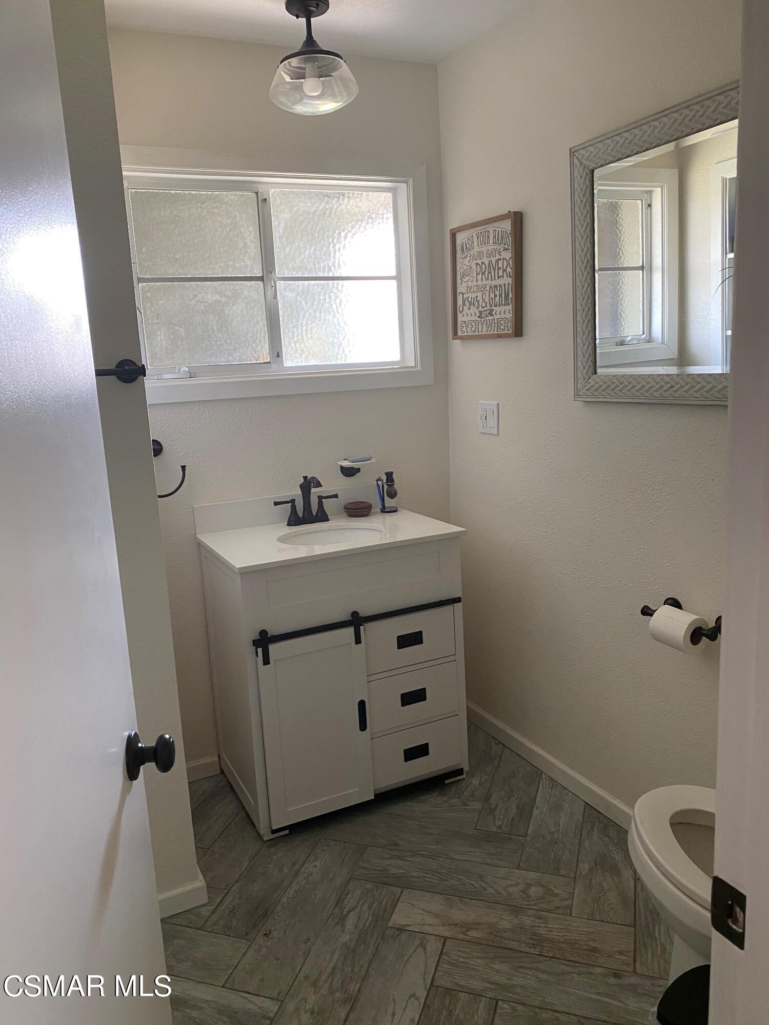 1209 West Roderick Avenue Oxnard, CA 93030 - Photo 16 of 30 a bathroom with a sink toilet and mirror