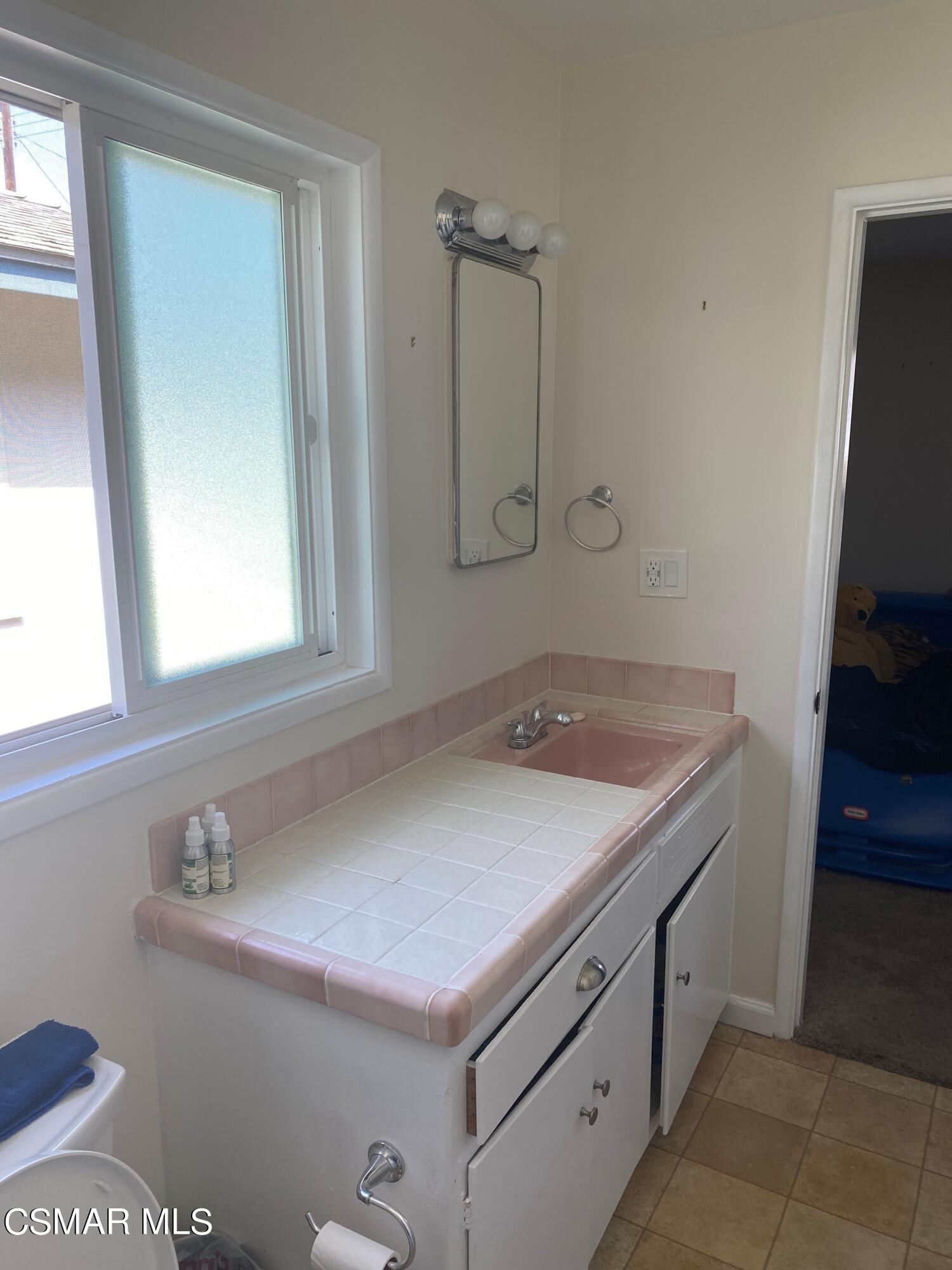 1209 West Roderick Avenue Oxnard, CA 93030 - Photo 18 of 30 a bathroom with a sink and a mirror