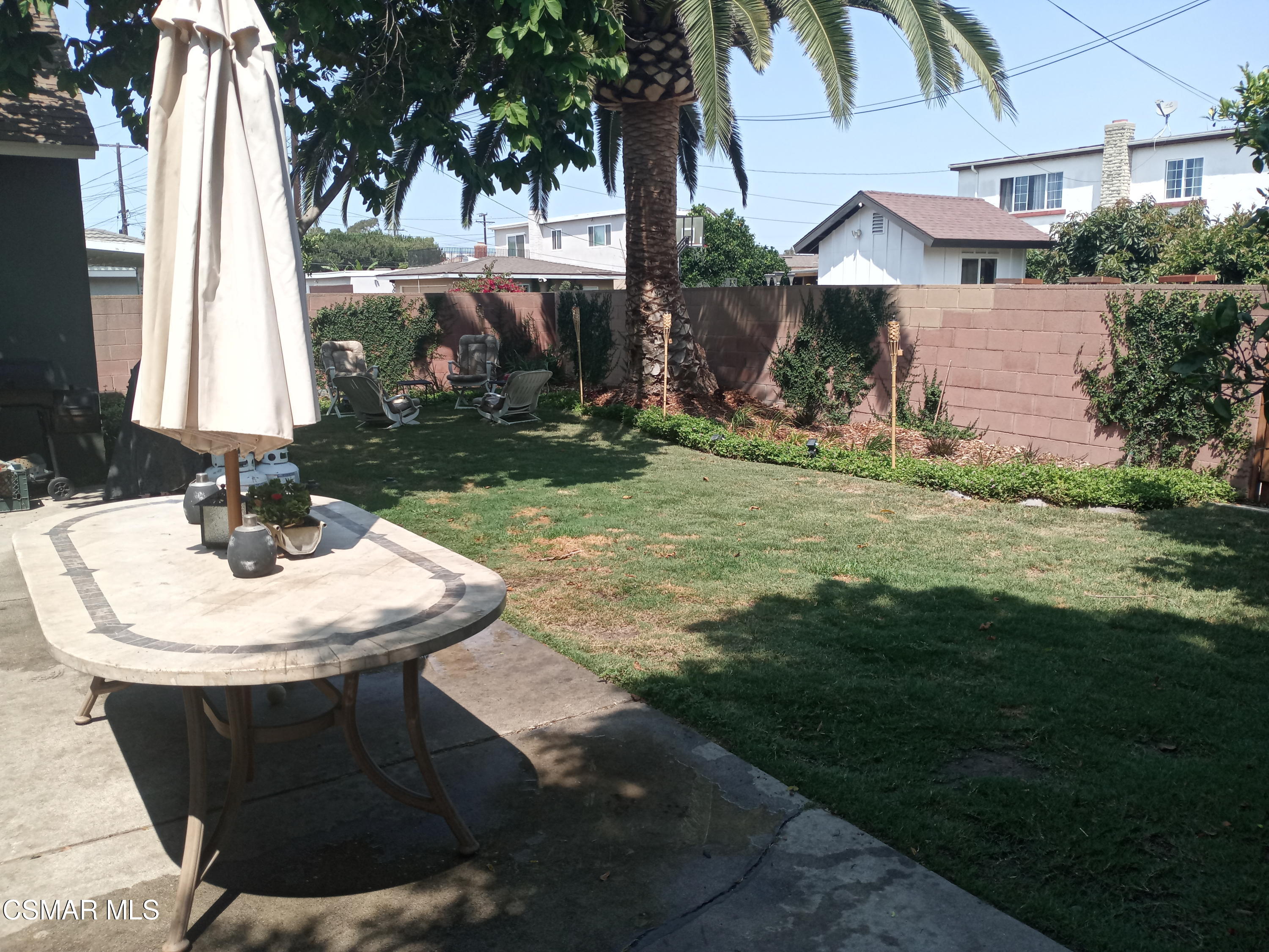 1209 West Roderick Avenue Oxnard, CA 93030 - Photo 28 of 30 a view of a backyard with table and chairs potted plants and palm tree
