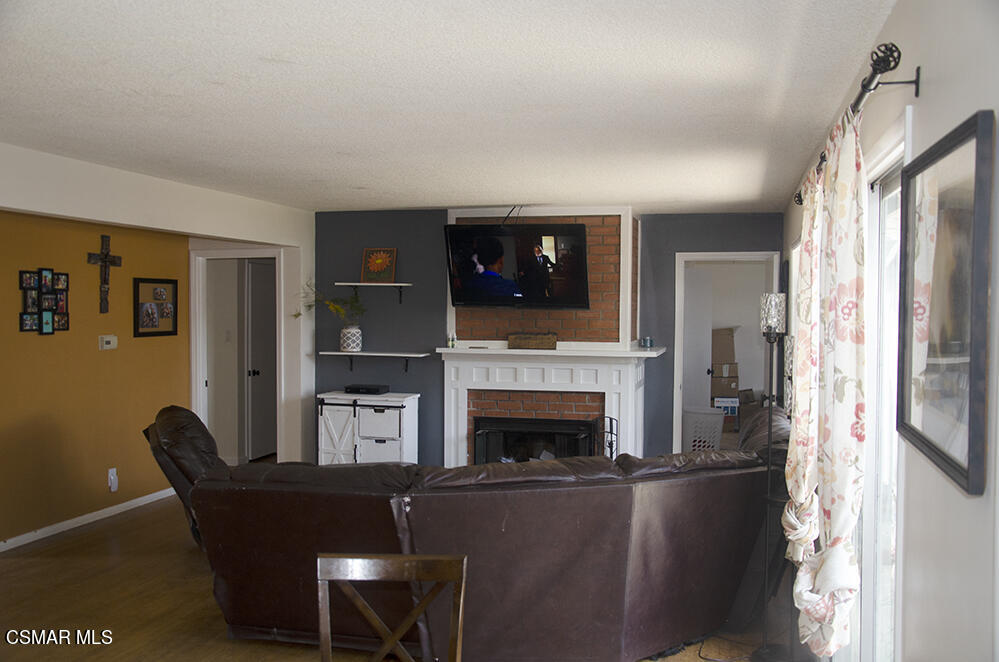 1209 West Roderick Avenue Oxnard, CA 93030 - Photo 6 of 30 a living room with furniture a fireplace and a flat screen tv