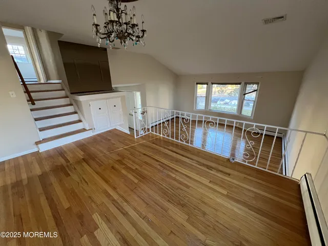 a view of a livingroom with wooden floor and staircase