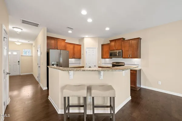 a kitchen with stainless steel appliances granite countertop a refrigerator and a stove top oven