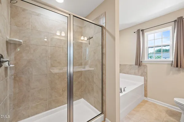 a bathroom with a bathtub shower and toilet