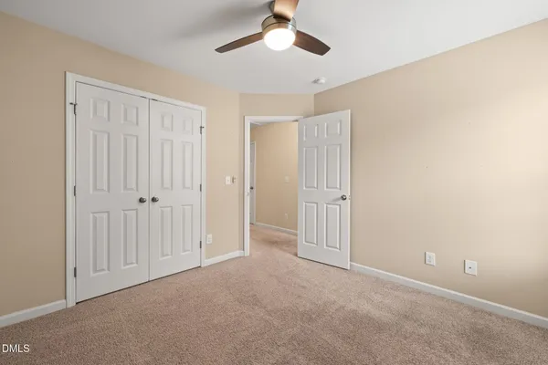 an empty room with chandelier fan