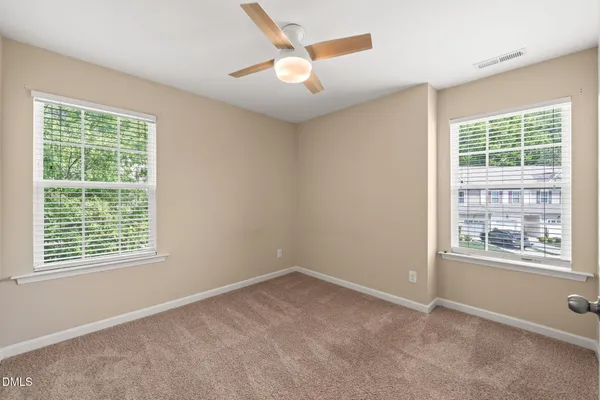 an empty room with a window and a ceiling fan