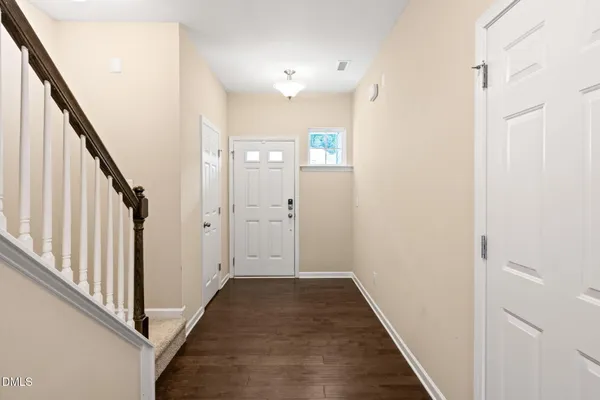 a view of a hallway with wooden floor and staircase