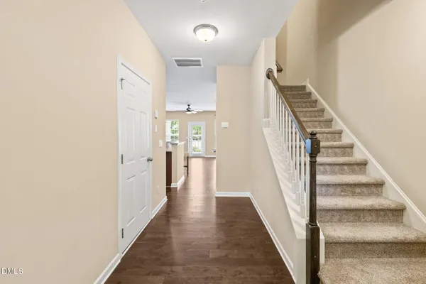 a view of a hallway with wooden floor and entryway