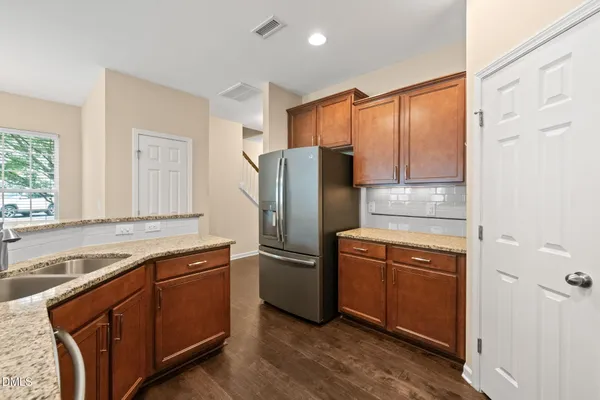 a kitchen with stainless steel appliances granite countertop a refrigerator and a sink