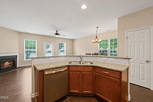 a kitchen with granite countertop stainless steel appliances a sink window and cabinets