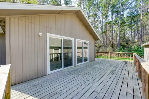 a view of backyard with large trees and wooden floor