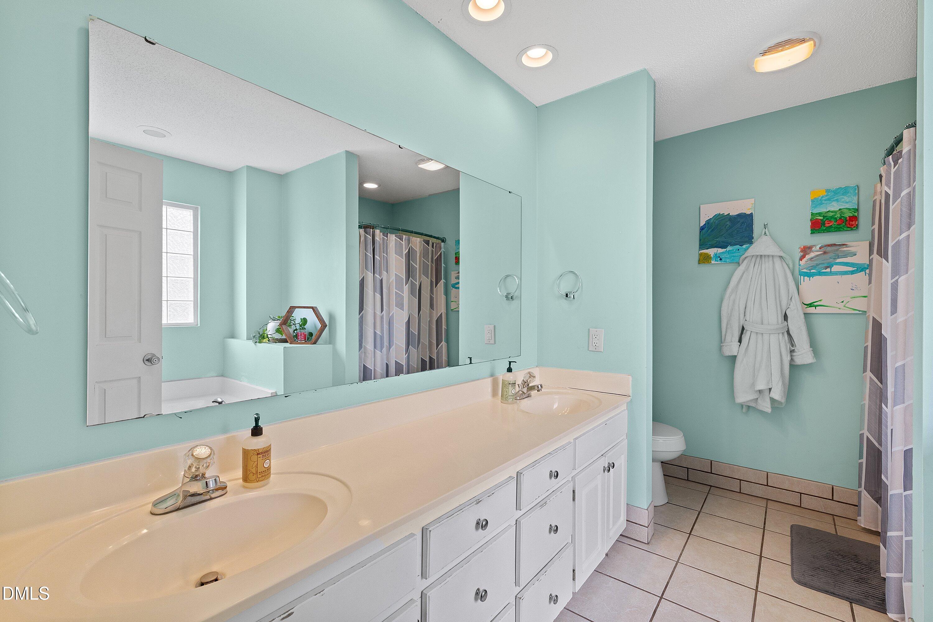 724 Iris Bryant Road Dunn, NC 28334 - Photo 13 of 22 a bathroom with a double vanity sink a mirror and a shower