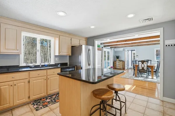 a kitchen with granite countertop a stove a sink and a refrigerator