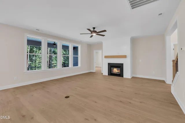a view of an empty room with a fireplace and a window