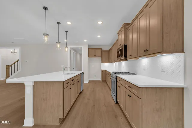 a kitchen with stainless steel appliances granite countertop a sink a stove and a refrigerator