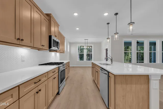 a kitchen with stainless steel appliances granite countertop a sink a stove and a refrigerator