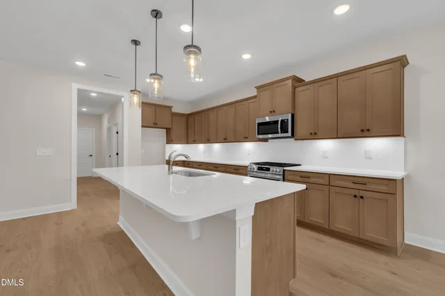 a kitchen with stainless steel appliances granite countertop a sink a stove and a refrigerator