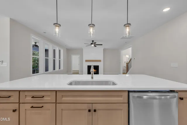 a view of living room with granite countertop furniture a fireplace and a ceiling fan