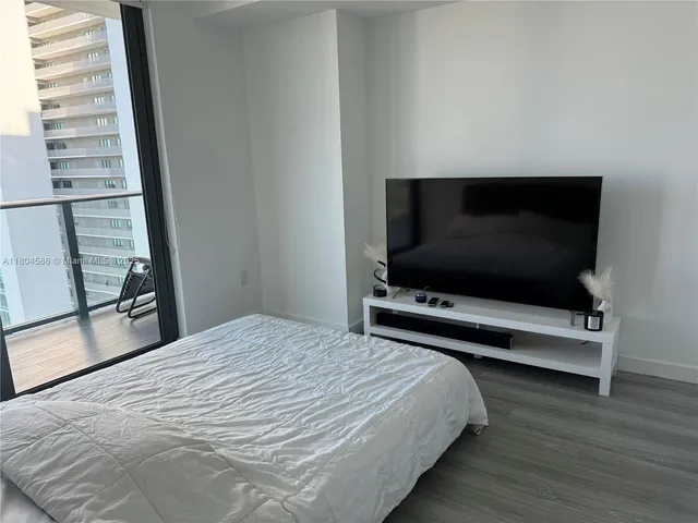 a bedroom with a bed and a flat screen tv
