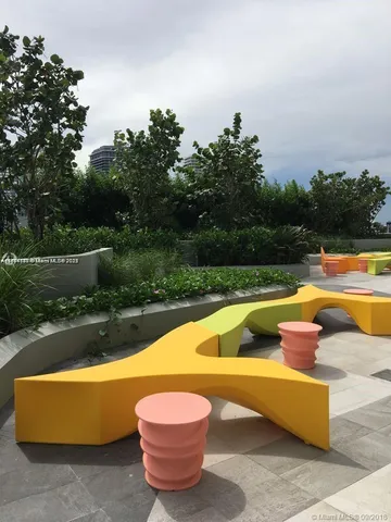 a living room with furniture and a floor to ceiling window