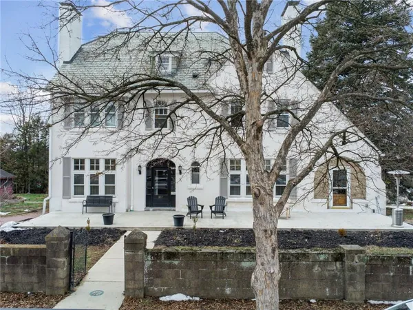 a front view of a house with large trees