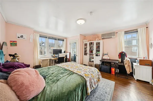 a spacious bedroom with a bed and wooden floor