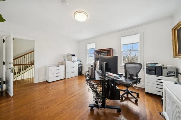 a view of a workspace with furniture and wooden floor