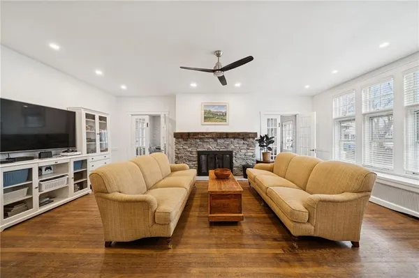 a living room with furniture a flat screen tv and a fireplace