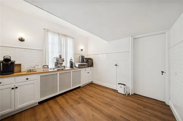 a kitchen with wooden floors and white cabinets