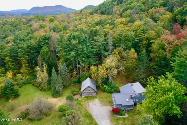an aerial view of residential house with outdoor space and trees all around