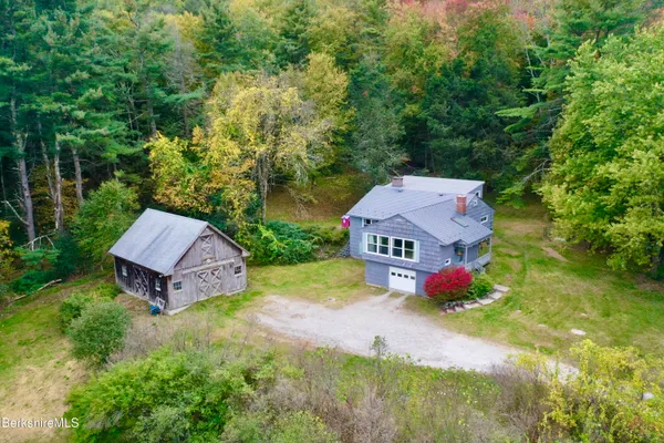 an aerial view of a house with yard and green space