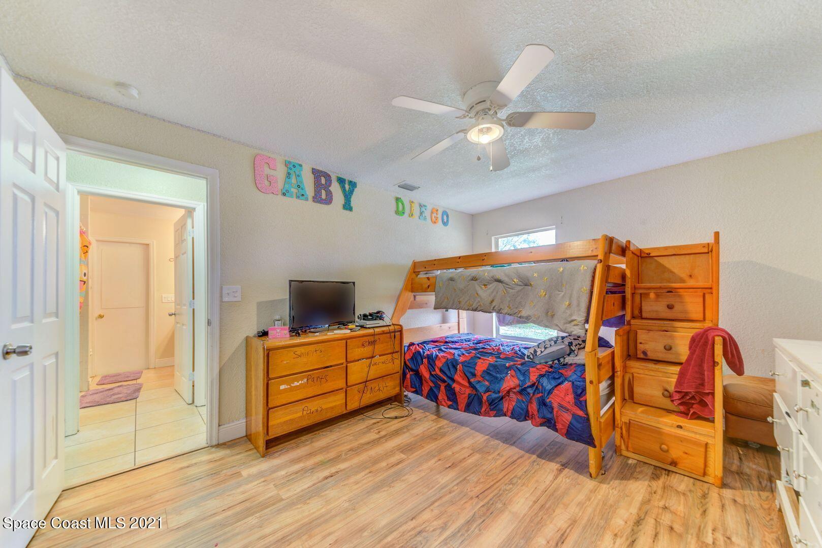 6025 Adina Road Cocoa, FL 32927 - Photo 15 of 22 a bedroom with a bed and a chandelier