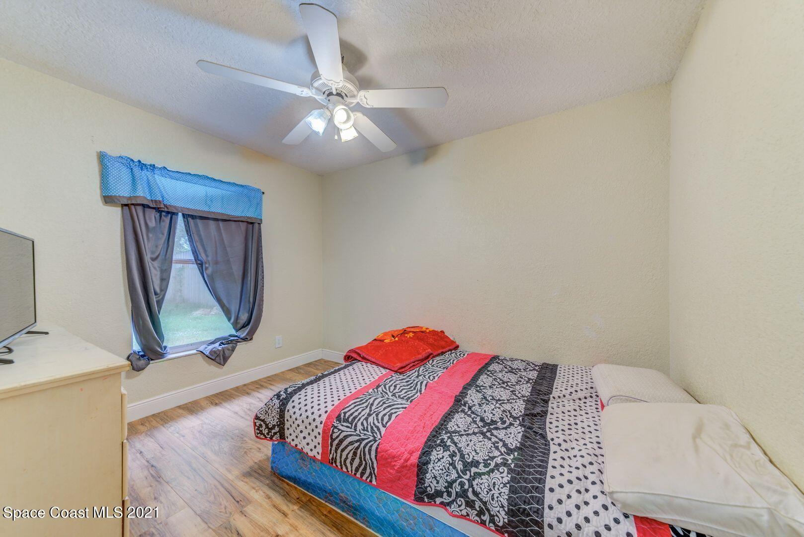 6025 Adina Road Cocoa, FL 32927 - Photo 16 of 22 a bedroom with a bed and a mirror